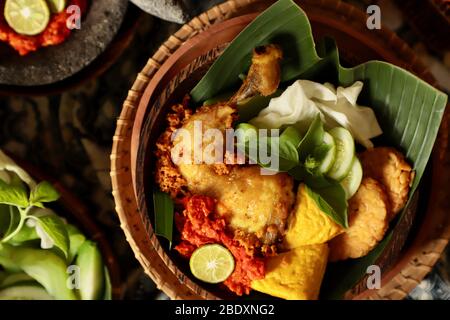 Ayam Penyet. Javanesische zertrümmerte, dann gebratene Hähnchenform mit roter Chilischote. Stockfoto