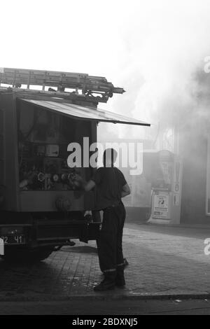 Die eigentliche Arbeit der Feuerwehrleute am Tatort. Löschen eines brennenden Gebäudes Stockfoto