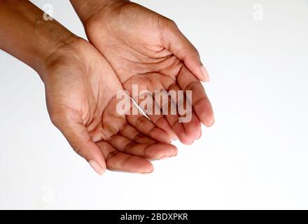 Isolierte weibliche schwarze afrikanische indische Hände schröpften zusammen und zeigten Bettelgesten vor einem weißen Hintergrund Stockfoto