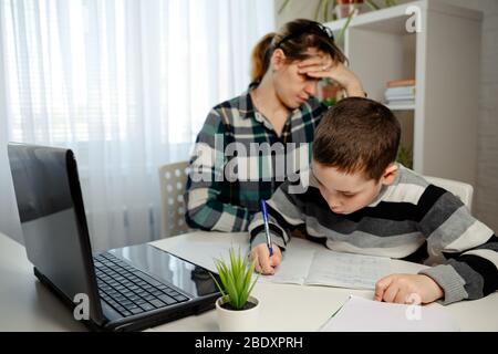 Schuljunge macht Schulaufgaben. Quarantäne und geschlossene Schule während des Coronavirus-Ausbruchs. Homeschooling. Online-Bildung und Fernunterricht Stockfoto