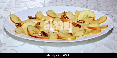 Frische Platte mit Mischung aus Cheddar-Käsebrüchen, Apfelscheiben und Wandnüssen zubereitet und auf weißem Teller für eine Verkostung angeordnet, Käse Verkostung Platte w Stockfoto