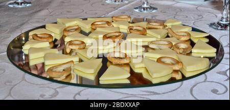 Lecker aussehende Käsearrangement auf Spiegelplatte, Verkostung Käse gepaart mit winzigen Brezeln auf schöner Platte, Bio und frisch Stockfoto