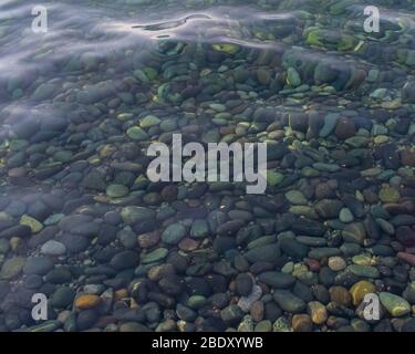 Ein klares Wasser mit glatten Kieselsteinen unter dem Wasser. Meerwasser Stockfoto