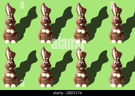 Ostermuster mit Schokoladenkaninchen auf hellgrünem Hintergrund. Ostern Konzept Bild mit Milch Schokolade Kaninchen Stockfoto