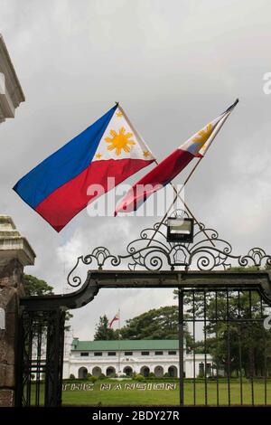 5. Juni 2019-Baguio City Philippinen: Wind weht auf zwei philippinische Flagge auf dem schwarzen hohen Tor des Herrenhauses in Baguio City Philippin Stockfoto