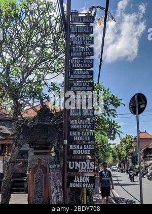 23. APRIL 2019-BALI INDONESIEN : Holzschilder mit Namen von Unterkünften und Hotels, die an einem hohen Stahlpfosten entlang der Straßen von Bali angebracht sind Stockfoto