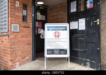 BUCKINGHAM, Großbritannien – 30. März 2020. Coronavirus COVID-19 Warnschild mit Präventionsangaben außerhalb eines Hausarztpraxis Stockfoto