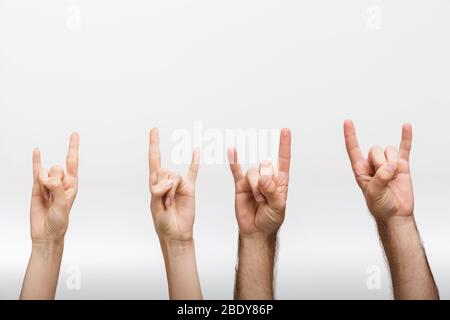 Nahaufnahme Bild eines Mannes und einer Frau Hände isoliert über weißen Wand Hintergrund zeigt Rock Geste. Stockfoto