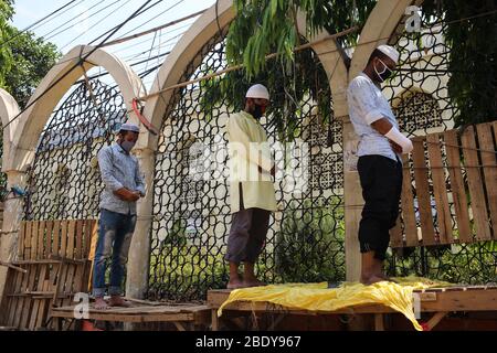 Dhaka, Bangladesch. April 2020. Die Menschen führen das Jumma-Gebet mit Handschuhen und Masken an der Außenseite der Baitul Mukarram Moschee durch, da sie nicht in die Moschee gehen durften. Die Regierung von Bangladesch hat alle Gebete, einschließlich der Freitagsgemeinden in Moscheen, ausgesetzt, um die Verbreitung von CoVid-19 zu verhindern. Die Zahl der Todesopfer wurde auf 27 erhöht und 424 Menschen wurden bisher von COVID-19 infiziert. (Foto: MD. Rakibul Hasan/Pacific Press) Quelle: Pacific Press Agency/Alamy Live News Stockfoto