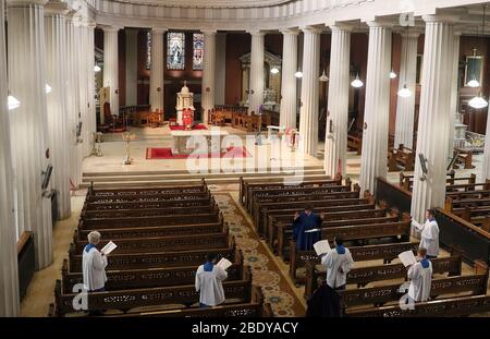 Mitglieder des Palestrina Chores üben soziale Distanz, während sie am Karfreitag in der St. Mary's Pro-Cathedral in Dublin während der Feier des "Lord's Passion"-Gottesdienstes auftreten. Liturgien werden über Web-Cam übertragen, um bei der sozialen Distanzierung im Kampf gegen die Ausbreitung des Coronavirus zu helfen. Stockfoto