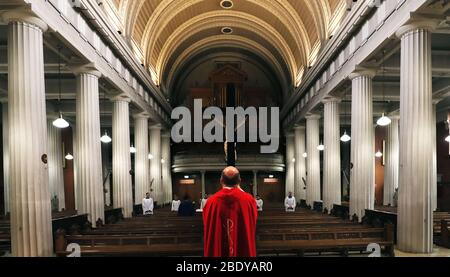 Fr. Kieran McDermot und Mitglieder des Palestrina Choir während der Feier des "Lord's Passion"-Gottesdienstes in der St. Mary's Pro-Cathedral in Dublin am Karfreitag. Liturgien werden über Web-Cam übertragen, um bei der sozialen Distanzierung im Kampf gegen die Ausbreitung des Coronavirus zu helfen. Stockfoto