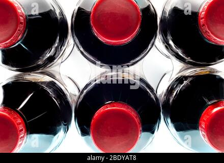 Horizontale Nahaufnahme eines Sechserpacks generischer alkoholfreier Getränke mit roten Kappen von oben. Weißer Hintergrund. Stockfoto