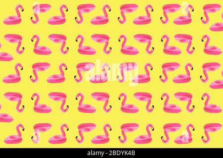 Kreatives Konzept von Strand und Sommerurlaub.Nahtloses Muster aus aufblasbaren rosa Mini Flamingos auf einem sandigen Hintergrund.Schwimmende aufblasbare Flamingo Stockfoto