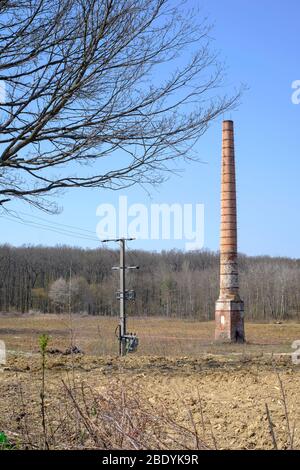 Hohe Industrie Kamin steht allein in der Mitte eines leeren Ödland einzigen Rest der früheren Fabrik zala County ungarn Stockfoto