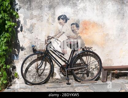 Zwei Kinder auf einem Fahrrad Wandgemälde von Ernest Zacharevic, Lebuh Armenian (Armenian Street), alten Kolonialviertel, George Town, Penang, Malaysia Stockfoto