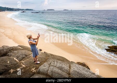 Eine Frau fotografiert den Strand von Palma Sola an der Pazifikküste Mexikos. Stockfoto