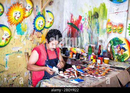 Ein Handwerker malt keramische Figuren in den populären Markt von Tonala, Jalisco, Mexiko. Stockfoto