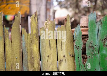 Detail des alten genagelten rostigen Holzzauns mit grüner Farbe abblätternd Stockfoto