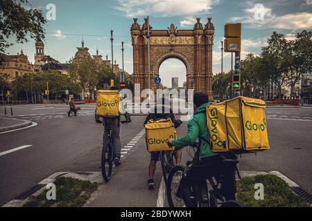 Barcelona, Spanien. April 2020. Fahrradkuriere fahren auf dem verlassenen 'Arc de Triomf' am Abend des 26. Tages einer landesweiten Sperre wegen der ständigen Ausbreitung des Virus. Spanien verzeichnete bisher fast 400 neue Todesfälle mit einer Todesrate von fast 16000 Todesfällen. Quelle: Matthias Oesterle/Alamy Live News Stockfoto