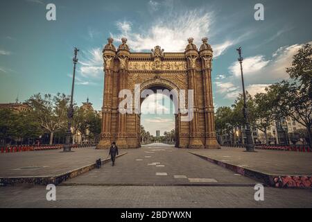 Barcelona, Spanien. April 2020. Ein Pendler geht am Abend des 26. Tages einer landesweiten Sperre wegen der ständigen Ausbreitung des Virus vor dem verlassenen 'Arc de Triomf' mit seinem Hund spazieren. Spanien verzeichnete bisher fast 400 neue Todesfälle mit einer Todesrate von fast 16000 Todesfällen. Quelle: Matthias Oesterle/Alamy Live News Stockfoto