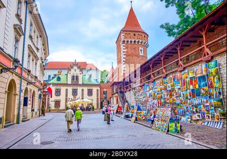 KRAKAU, POLEN - 12. JUNI 2018: Die Touristen im alten Krakau spazieren und genießen die Kunstwerke der lokalen Handwerker in berühmten Kunstmarkt am St. Florian's Gate, ON Stockfoto