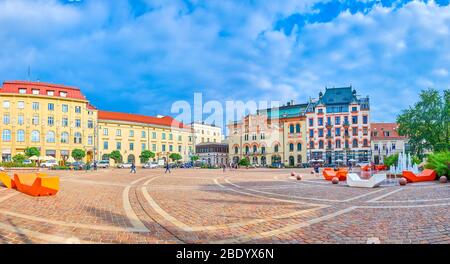 KRAKAU, POLEN - 12. JUNI 2018: Der große Szczepanski-Platz mit Brunnen und bunten modernen Bänken ist mit einem prächtigen historischen Gebäude umgeben Stockfoto