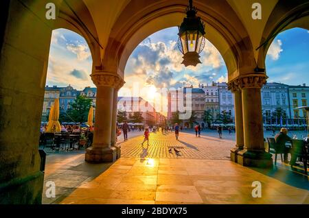 KRAKAU, POLEN - 12. JUNI 2018: Die hellen Abendsonnen leuchten am 12. Juni in Krakau durch die Lauben von Sukiennice Stockfoto