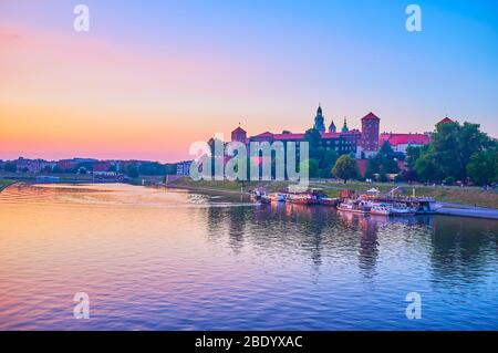 KRAKAU, POLEN - 12. JUNI 2018: Die Silhouette des Wawel-Schlosses spiegelt sich in der Abendbeleuchtung auf der Weichsel, am 12. Juni in Krakau Stockfoto