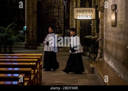 Barcelona, Katalonien, Spanien. 10. Apr 2020 - Altarjungen gehen am Karfreitag an der Kathedrale von Barcelona vorbei. Die Maßnahmen der sozialen Distanzierung aufgrund der Pandemie durch das Covid-19-Virus machen die diesjährigen Osterfeierlichkeiten leer von Gläubigen, die Messe anlässlich des Karfreitags in der Kathedrale von Barcelona wurde live in sozialen Netzwerken übertragen. Quelle: Jordi Boixareu/Alamy Live News Stockfoto