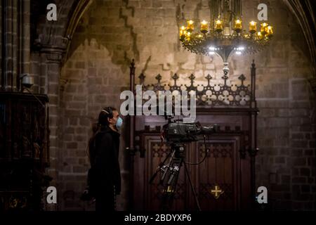 Barcelona, Katalonien, Spanien. 10. Apr 2020 - EIN Fernsehteam, das eine schützende Gesichtsmaske trägt, wird während der Karfreitagsmesse in der leeren Kathedrale von Barcelona gesehen. Die Maßnahmen der sozialen Distanzierung aufgrund der Pandemie durch das Covid-19-Virus machen die diesjährigen Osterfeierlichkeiten leer von Gläubigen, die Messe anlässlich des Karfreitags in der Kathedrale von Barcelona wurde live in sozialen Netzwerken übertragen. Quelle: Jordi Boixareu/Alamy Live News Stockfoto