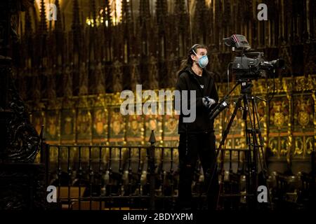 Barcelona, Katalonien, Spanien. 10. Apr 2020 - EIN Fernsehteam, das eine schützende Gesichtsmaske trägt, wird während der Karfreitagsmesse in der leeren Kathedrale von Barcelona gesehen. Die Maßnahmen der sozialen Distanzierung aufgrund der Pandemie durch das Covid-19-Virus machen die diesjährigen Osterfeierlichkeiten leer von Gläubigen, die Messe anlässlich des Karfreitags in der Kathedrale von Barcelona wurde live in sozialen Netzwerken übertragen. Quelle: Jordi Boixareu/Alamy Live News Stockfoto