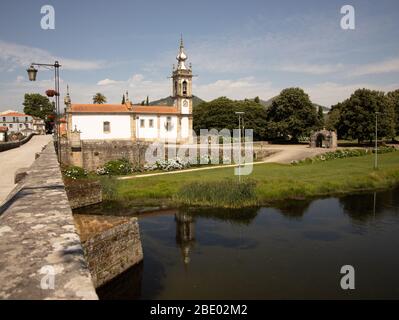 Blick auf den Fluss Lima durch die Brücke Ponte Medieval und die weiße hübsche Kirche Igreja de Santo António Ponte de Lima Nord Portugal Stockfoto