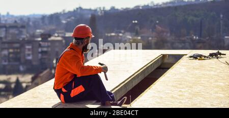 Wärmedämmung. Professionelles Reparaturdach. Flachdachmontage. Dachdecker baut neues Dach. Man Dachfläche. Schätzen Sie den Materialbedarf für Projekte. Installation von Dachmaterialien Stockfoto