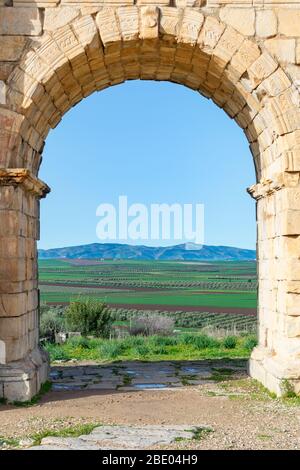 Ein Blick durch den Caracalla-Bogen auf die römischen Ruinen von Volubilis in Marokko Stockfoto