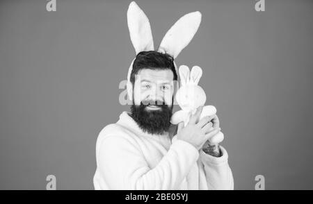 Respekt für Traditionen. Mann mit bunnem Plüschanzug. Lustiger Häschen-Mann mit Bart und Schnurrbart. Ostersymbol Konzept. Guy bärtigen Hipster niedlich sanften Hase lange Ohren blauen Hintergrund. Osterhasen. Stockfoto