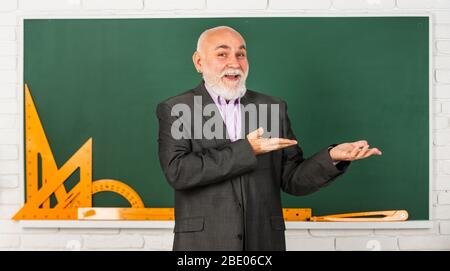 Präsentation Produkt. Holen Sie sich Wissen hier. Senior Mann Lehrer verwenden mathematische Werkzeuge. Bärtigen Dozent Mann erklären Geometrie auf Tafel. Zurück zur Schule. Mathematische grafische Werkzeuge. trigonometrie Unterricht im Klassenzimmer. Stockfoto