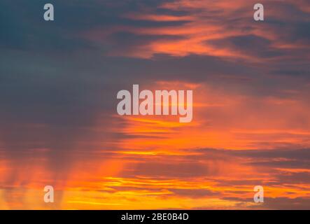 Schöner Himmel mit gelben, orangen und roten Farben durch den Sonnenuntergang. Verschiedene Arten von Wolken sichtbar. Stockfoto