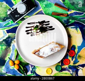 Kuchen mit Zuckerpulver und Eis mit Schokolade auf der Oberseite Stockfoto