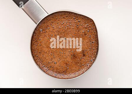Schwarzer Kaffee in türkischer Kaffeekanne, Draufsicht auf weißem Tisch Stockfoto