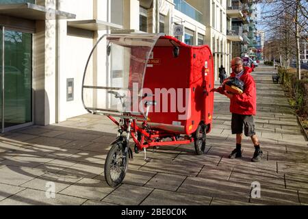 Radfahren Royal Mail Postbote auf elektrischen Lastenrad, e-Trike, angetrieben durch eine Kombination aus Solar-, Batterie-, Pedal- und Bremstechnologie Stratford London UK Stockfoto