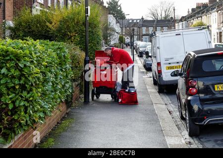 Royal Mail Postbote in der Wohnstraße in London England Vereinigtes Königreich Großbritannien Stockfoto