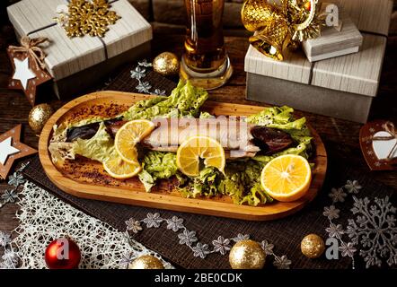 Geräucherter Fisch mit Kräutern und in Scheiben geschnittenen Zitronen Stockfoto