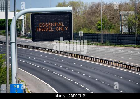 Hinweisschilder mit der Aufschrift „Essential Travel Only“ auf der M5 in der Nähe von Bristol, da staatliche Beschränkungen weiterhin versuchen, das Coronavirus einzudämmen. Stockfoto