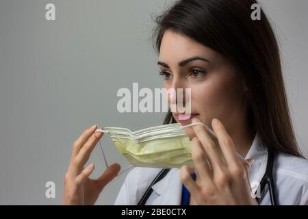 Weibliche Gesundheitsarbeiterin, die Maske aufsetzt. Anlegen von PSA für die Sicherheit im Krankenhaus. Könnte Krankenschwester Praktiker, MD, PA, Krankenschwester, Arzt, DO, etc. Sein Stockfoto