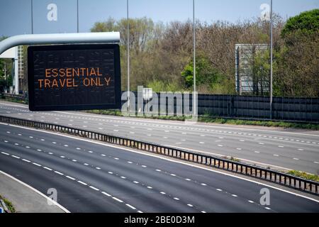 Hinweisschilder mit der Aufschrift „Essential Travel Only“ auf der M5 in der Nähe von Bristol, da staatliche Beschränkungen weiterhin versuchen, das Coronavirus einzudämmen. Stockfoto