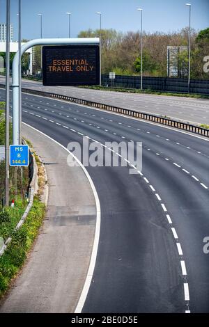 Hinweisschilder mit der Aufschrift „Essential Travel Only“ auf der M5 in der Nähe von Bristol, da staatliche Beschränkungen weiterhin versuchen, das Coronavirus einzudämmen. Stockfoto