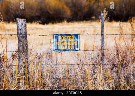 Schild „geschrieben, kein Trespassing, Keep Out“ am Zaun der Ranch in der Mitte von Colorado Stockfoto