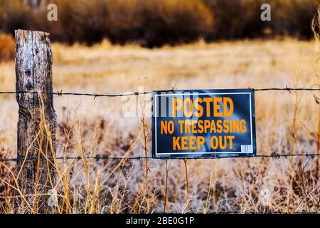 Schild „geschrieben, kein Trespassing, Keep Out“ am Zaun der Ranch in der Mitte von Colorado Stockfoto