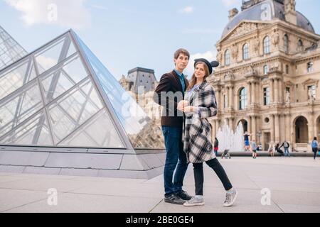 Verliebte Touristen vor dem Louvre und der Pyramide des Louvre. Der Louvre ist eines der größten und meistbesuchten Museen der Welt. Stockfoto