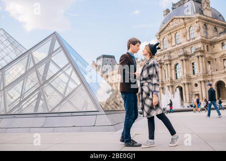 Verliebte Touristen vor dem Louvre und der Pyramide des Louvre. Der Louvre ist eines der größten und meistbesuchten Museen der Welt. Stockfoto